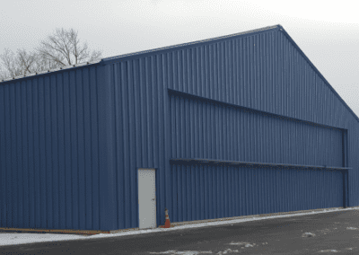 A big blue shed surrounded with snow.